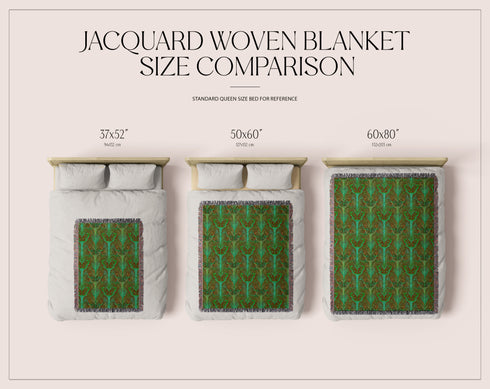 A woven cotton throw featuring an intricate luna moth design in deep green and russet tones, framed by soft fringe.